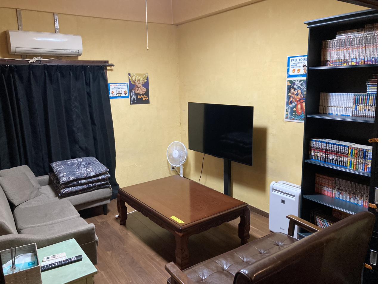 ソファと大型テレビ、マンガ棚のある居間